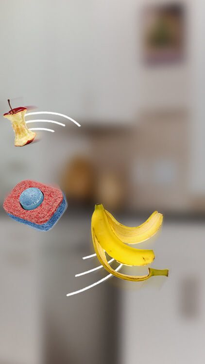 A banana, an apple core and a leaf spinning around a dishwasher tablet