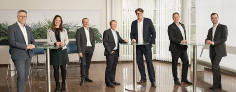 Das BASF Renewable Energy GmbH - Team steht nebeneinander im Foyer des Bürogebäudes.