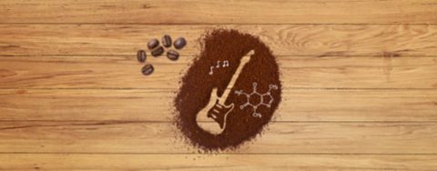 Electric guitar drawn as an outline in a heap of coffee grounds