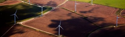 Wind Turbines amidst some colorful fields in Kent viewed from air.