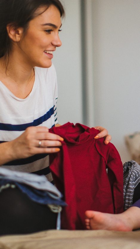 Mother and her daughter folding laundry together