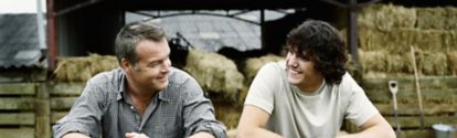 Dos hombres apoyados en la barandilla de la granja sonriendo BASF Mexico
