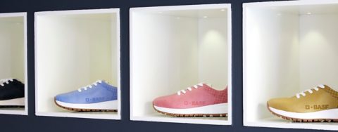 Four shoes with BASF logo  in four colors on a shelf.