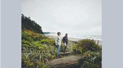Mann und Frau stehen in einer Landschaft die am Strand grenzt