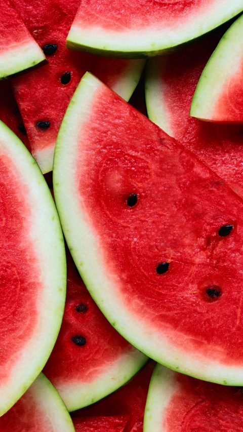 A large number of cut slices of ripe watermelon.Texture or background