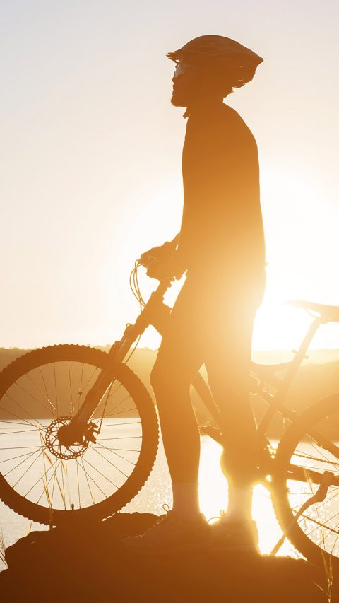 Silhouette of a man on mountain-bike during sunset.
