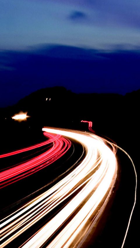 long exposed image of highway at night with red and yellow lines 