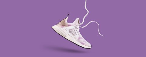 Pattern made of many white trendy sneakers on purple pastel background