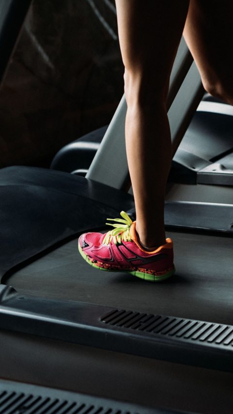 Young Woman Running On Treadmill In Gym